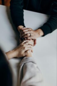 A mom holding her son's hand representing her support of him during his outpatient treatment.