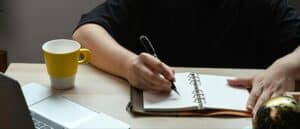 A close-up of hands jotting notes or journaling during an outpatient session, symbolizing reflection and cognitive work.