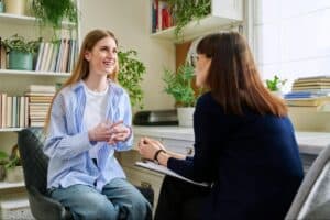 A healthcare professional speaking with a patient in a bright office with natural light to help her understand her opioid treatment options.