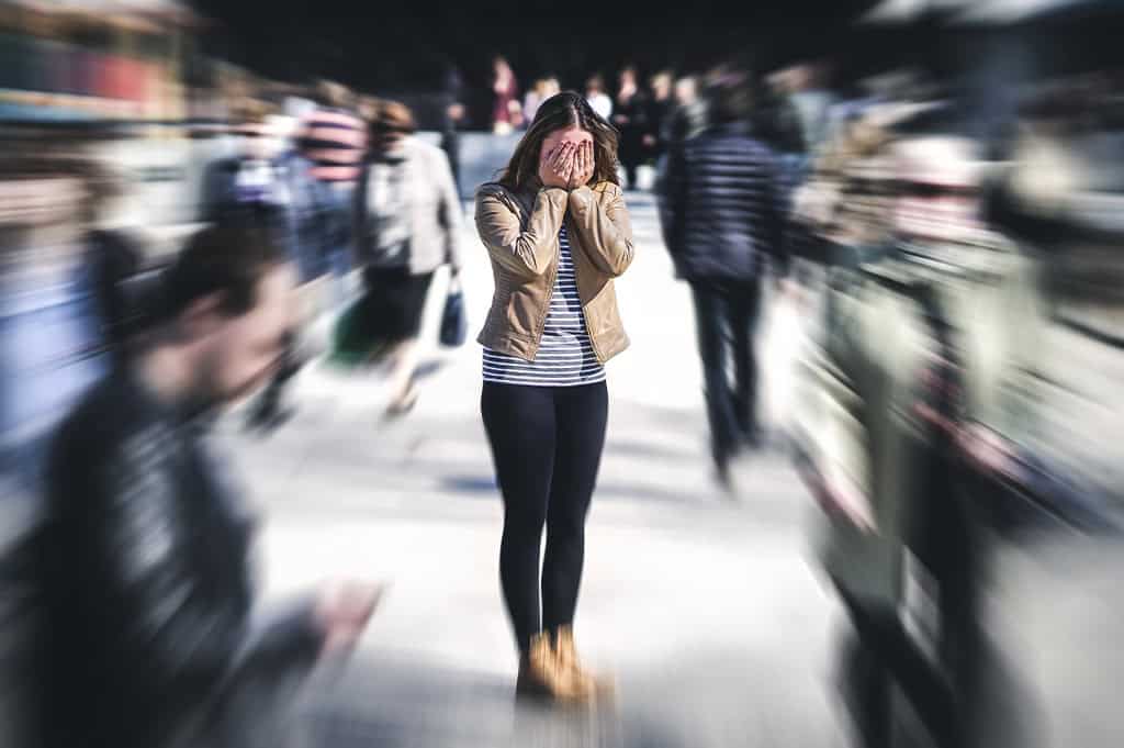 woman having a panic attack on a crowded street in need of panic attack treatment
