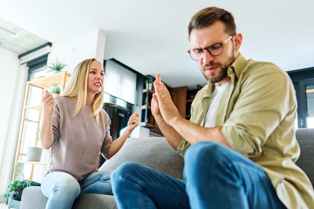 Couple arguing on the couch showing how Alcoholism is Selfish