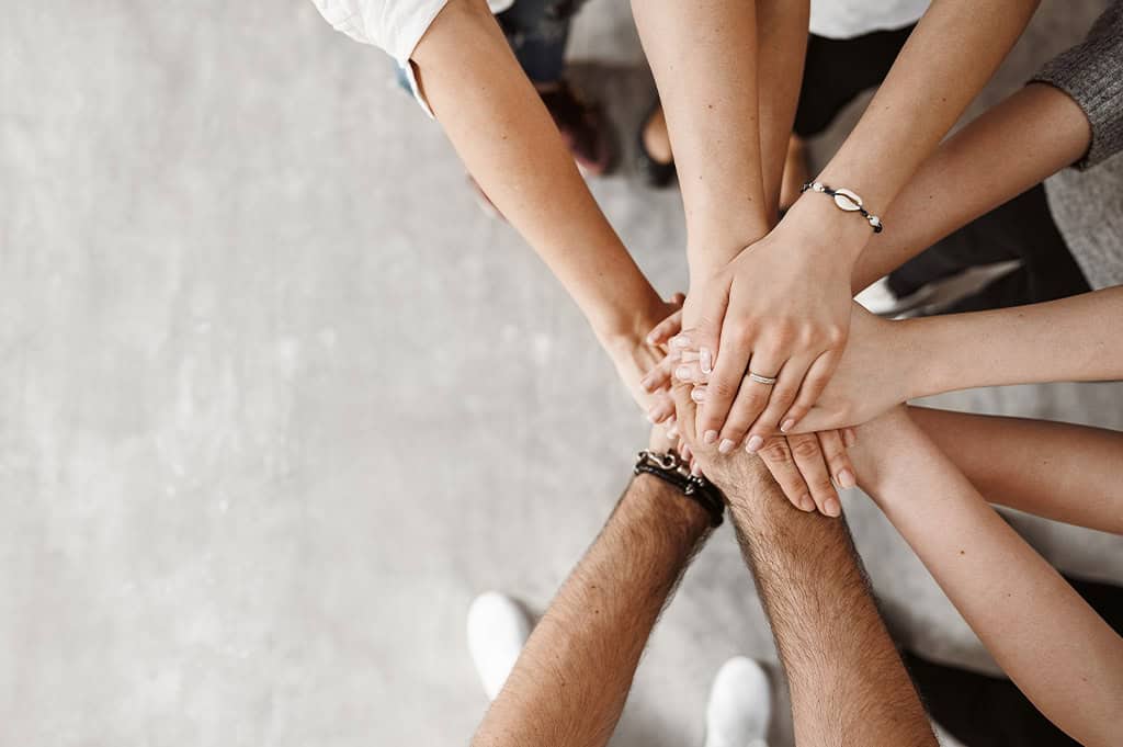 supportive group joining hands to show support to one another