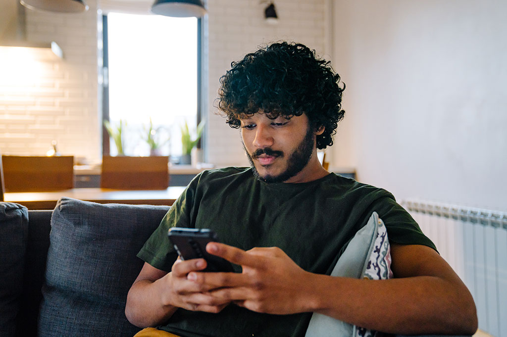 Man at home researching whether insurance covers drug rehab in Massachusetts