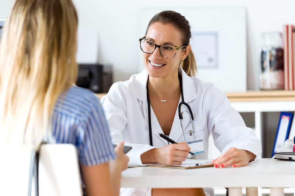 female doctor sitting with female patient explaning what she should expect in a medical detox