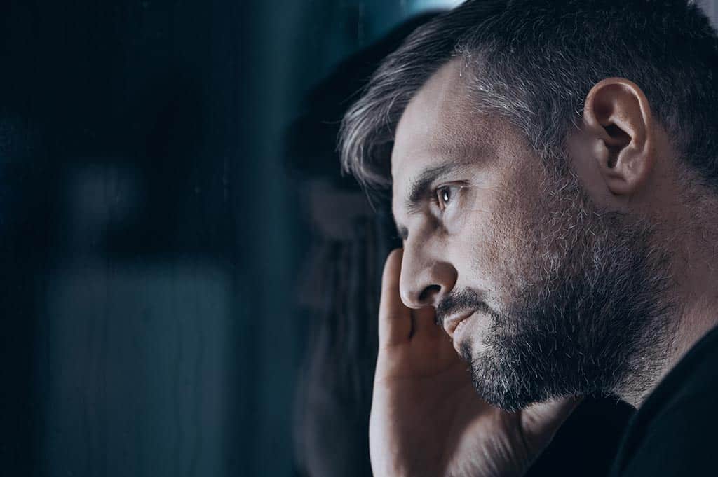 Man experiencing 7-OH withdrawal looking out a window