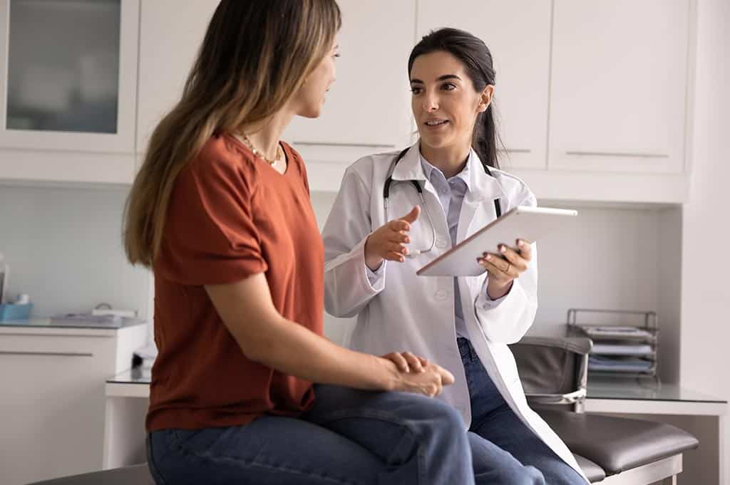 Doctor reviewing kratom drug test information on a tablet with a patient