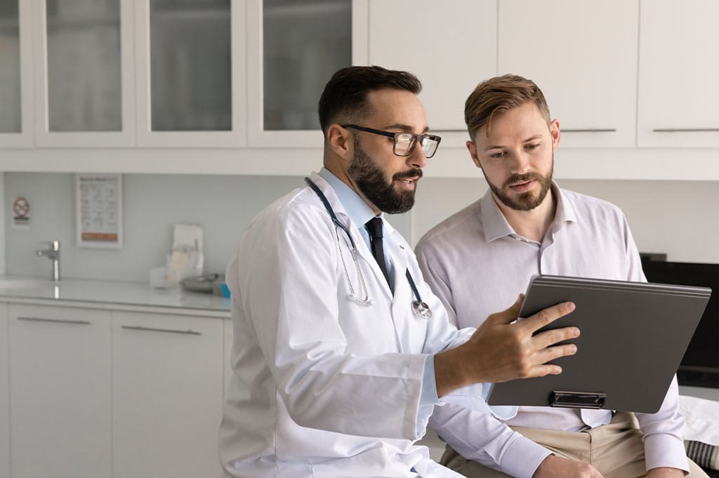 A doctor reviews Vivitrol treatment information with a patient during a clinic consultation.
